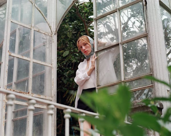 free-photo-of-woman-in-white-shirt-looking-out-from-glass-door